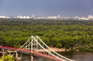 Dnipro nehri üzerindeki yaya Park köprüsünün manzarası. Yağmurdan sonra bulutlu gökyüzü. Yaz
