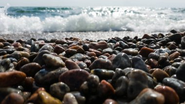 Çakıl plaj ve arka plan olarak yaklaşan dalga. Sakin kavram