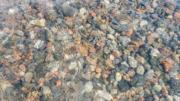 Spiaggia di ghiaia come sfondo. Concetto tranquillo. Ciottoli attraverso acqua limpida — Foto Stock