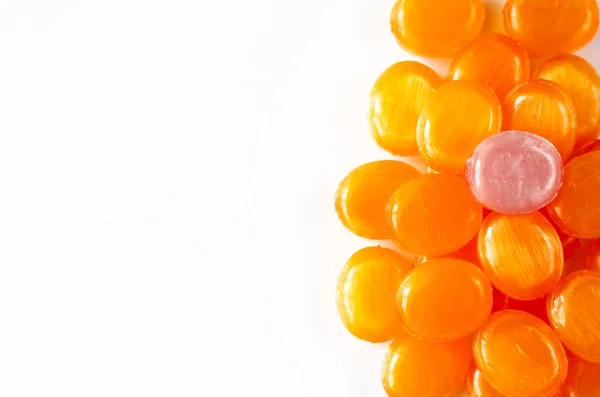 Primo piano di caramelle di frutta succhiare duro su uno sfondo bianco. Un mazzo di caramelle all'arancia e una rosa. Ricevuto. Vista dall'alto — Foto Stock