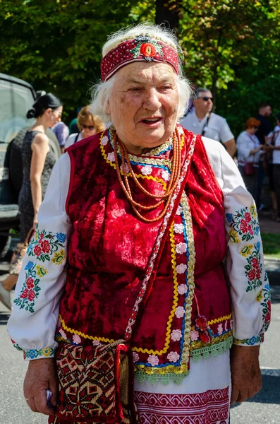 Kyiv, Ukraine - August 24, 2019. Vladimirskaya St. An elderly woman in Ukrainian national clothes, in an embroidered shirt, with an embroidered bag over his shoulder. Ukraine's Independence Day — Stock Photo, Image