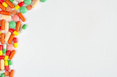 Beyaz bir arka plan üzerinde çok renkli haplar, tabletler ve kapsülyığınları. İlaçların yakın çekim. Kopya alanı. Üstte görüntü