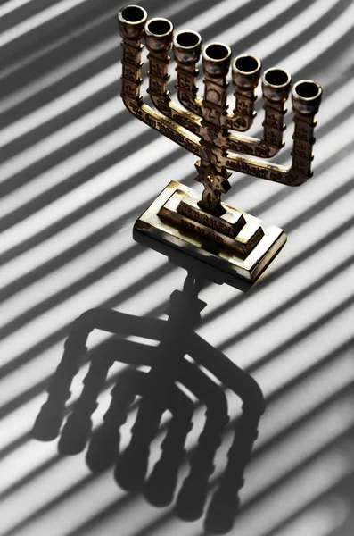 Tradycyjna srebrna Menorah żydowska na białym tle z paskami cienia z blindów — Zdjęcie stockowe