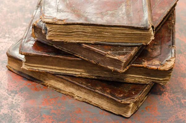 Stack of old and worn leather cover books with gold leaf embossing. Closeup — Stock Photo, Image