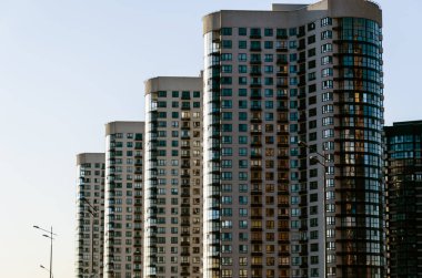 Perspektifte berrak mavi gökyüzüne karşı modern yüksek katlı binalar bir satır. Kentsel arka plan. Kentsel yayılma kavramı