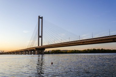 Güney köprüsü, Kiev, Ukrayna. Güzel bir gün batımının arka planında Dnipro nehri üzerinde Kiev köprüsü. Akşam güneşinde köprü