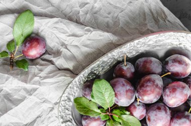 Metal bir vintage çanak taze organik erik. Olgun ve sulu meyvelerin natürmortu