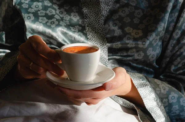 Café du matin au lit. Une tasse de café dans les mains des femmes au soleil du matin. J'aime les petites choses. Gros plan — Photo