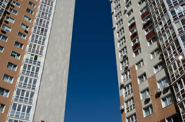 Modern residential high-rise buildings against a clear blue sky. Urban background. Urban sprawl concept