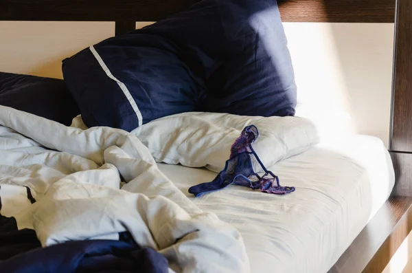 Culotte femme en dentelle bleue sur un lit froissé. Matin après une nuit chaude. Contexte du concept sexuel — Photo