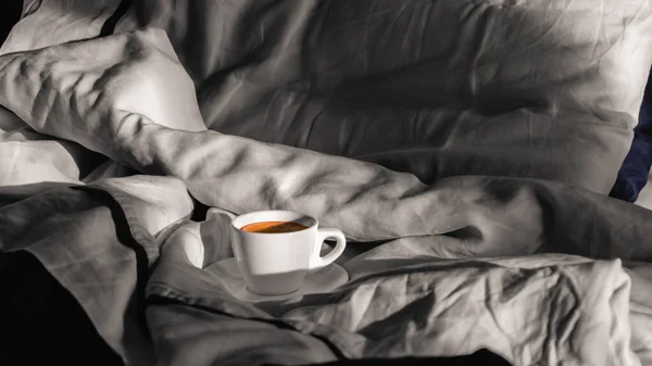 Café du matin au lit. Tasse blanche de café sur un lit gris au soleil du matin. J'aime les petites choses. Hygge. Concept de vie lente — Photo