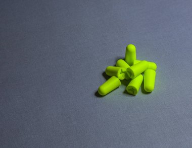 Gri bir arka plan görüntüsü üzerinde yeşil kulak tıkacı