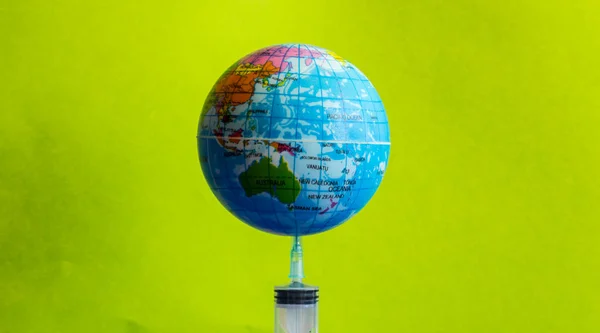 A modell föld a fecskendőt a zöld háttér-kép — Stock Fotó