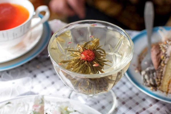 Boire du thé vert en verre transparent avec des fleurs — Photo