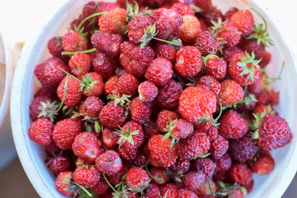 Red fresh strawberry with green leaves in white bucket from above — Stock Photo, Image