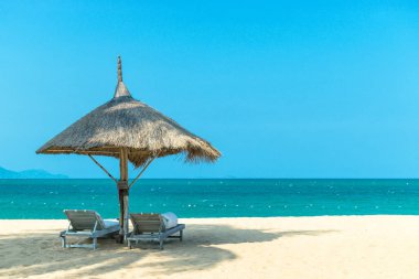 Berrak mavi gökyüzü gününde şemsiye ile plajda Pastoral manzara cennet sahnesi