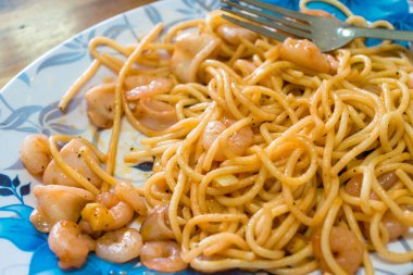 Süs ile tabakta kızarmış deniz ürünleri ile Haşlanmış spagetti