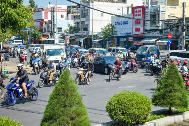 Nha Trang, Vietnam - 13 Nisan 2019: Bol motosikletçi gün içinde yoğun saatlerde çalılarla yolda