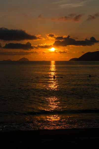 Bulutlar ile şafakta deniz suyu üzerinde parlak güneş ışığı turuncu iz