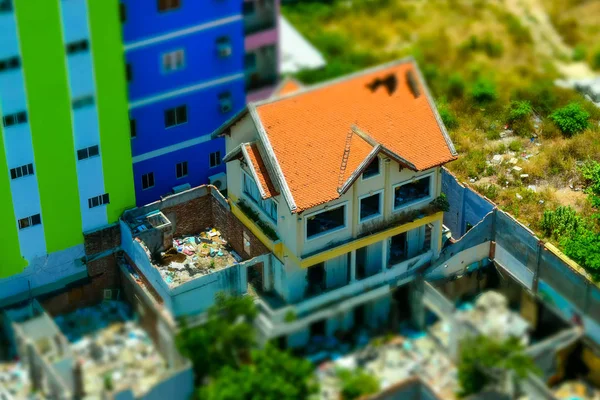 Vista superior na casa arruinada com telhado de azulejo perto do edifício moderno — Fotografia de Stock