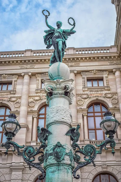 Sculpture of woman with two wreaths on top of pillar in Vienna Austria with blue sky — Stock Photo, Image