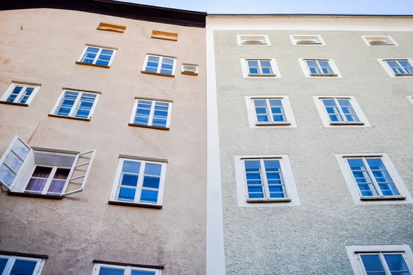 奥地利萨尔茨堡老建筑的外墙，有一排窗户，一个开着的窗户 — 图库照片
