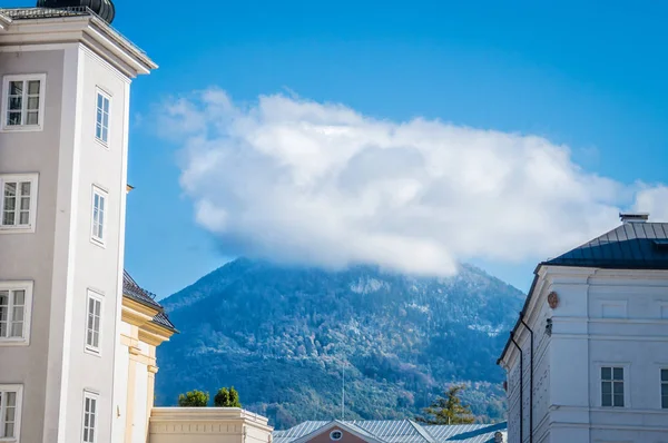 Salzburg Avusturya'da iki bina arasında bulut altında dağ görünümü — Stok fotoğraf