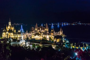 Deniz üzerinde füniküler ile gece eğlence parkında Parlayan binalar