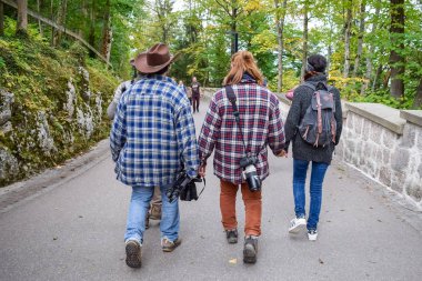 Schwangau, Almanya - Oktober 09, 2018: Sonbahar ormanında kameralarla ekose gömlekli Amerikalı turistler