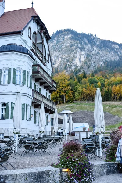 SCHWANGAU, ALEMANIA - OKTOBER 09, 2018: Café cerca de un edificio en un parque por la mañana en los Alpes —  Fotos de Stock