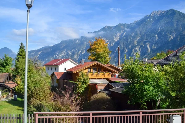 Στέγες όμορφων σπιτιών σε ένα χωριό στις Άλπεις το φθινόπωρο με βουνά στο παρασκήνιο — Φωτογραφία Αρχείου