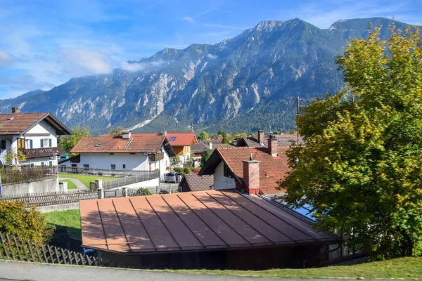 Alpler'de bir köyde evlerin çatıları üzerinde Dağ manzarası — Stok fotoğraf