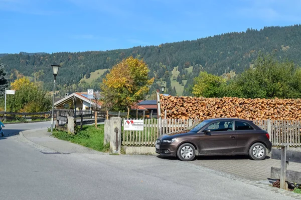 Oberammergau, Németország-Oktober 09, 2018: autó és cölöp tűzifa mellett egy falusi ház az Alpokban ősszel — Stock Fotó