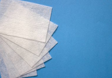 Mavi arka planda tüy bırakmayan mendiller. Manikür için Profesyonel Tırnak Bakım Araçları. Vernik kaldırma Küçük tırnak sanat ve manikür iş. Tırnak Cilası ve yağ giderme aracı.