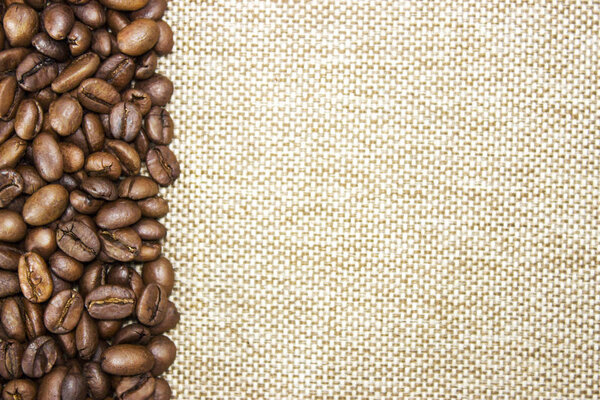 Roasted coffee beans left on a burlap background. Free space for text, menu