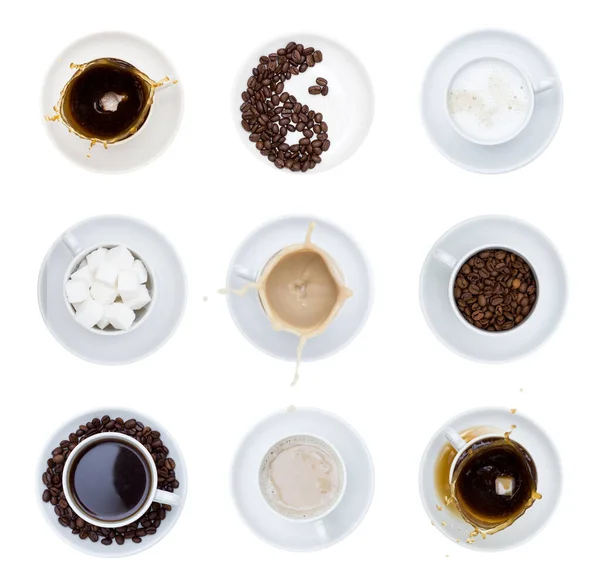 White cups and saucers with coffee, tea, coffee beans and sugar. Set of cups on a white background, isolated. Splashes, top view.