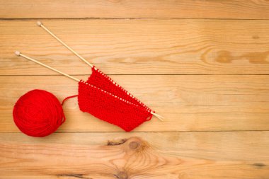 Ahşap arka planda telleri olan kırmızı iplik yumağı, metin için boş alan.