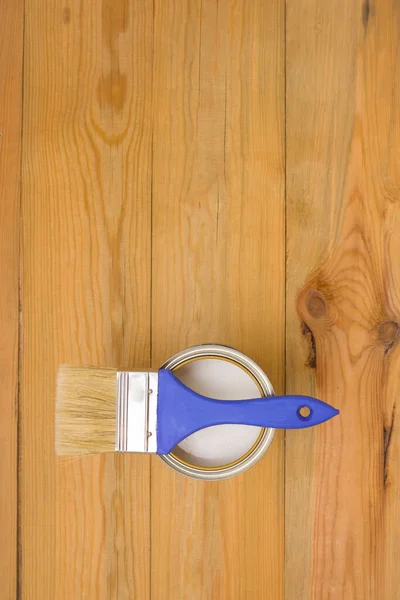 Tools for construction and decoration. Painting. A paintbrush and a metal can of paint. Wooden background, top view, copyspace.