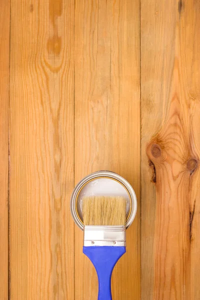 Tools for construction and decoration. Painting. A paintbrush and a metal can of paint. Wooden background, top view, copyspace.