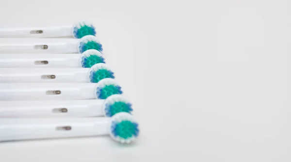 Parts of an electric toothbrush are laid out in a row, white background, free space for text. — Stock Photo, Image