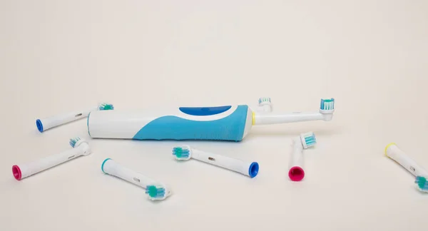 Electric toothbrush and removable parts from it on a white background. Free space for text. — Stock Photo, Image