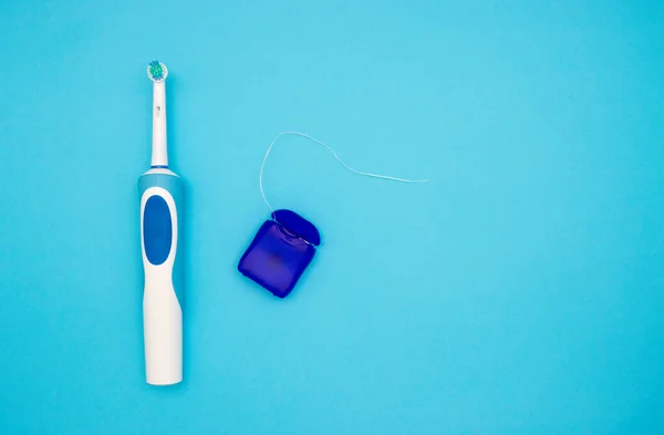 Oral Hygiene Electric Toothbrush Dental Floss Blue Background View Top — Stock Photo, Image