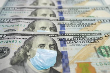 Benjamin Franklin 'in yüz maskeli yüz dolarlık banknotu. Coronavirus küresel borsayı etkiler. Dünya ekonomisi Corona virüsü salgını ve salgın korkularıyla sarsıldı. Kriz ve finans kavramı.