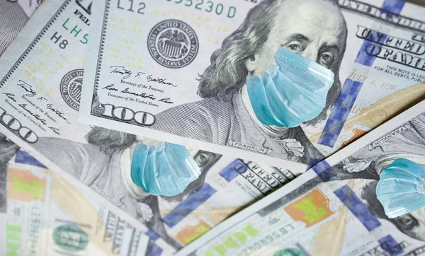 One Hundred Dollar Bill With Medical Face Mask on Benjamin Franklin. Coronavirus affects global stock market. World economy hit by corona virus outbreak and pandemic fears. Crisis and finance concept.