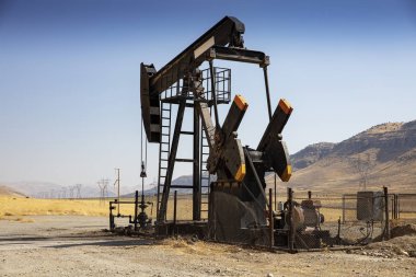 Çöl petrol sahasında petrol sondaj rayları. Yerden ham petrol üretimi. Petrol işleri müteahhidi. Petrol sondaj kulesi ve pompa kriko. Petrol üretimi, doğal gaz, sıvılar, Ngl, katkı maddesi.