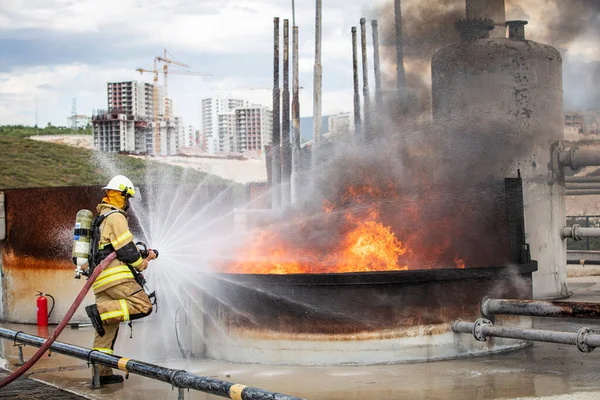Feuerwehrmann Mit Wasser Und Feuerlöscher Bei Der Bekämpfung Der Flammen — Stockfoto