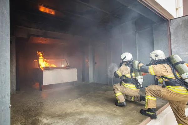 Feuerwehrmann Mit Wasser Und Feuerlöscher Bei Der Bekämpfung Der Flammen — Stockfoto