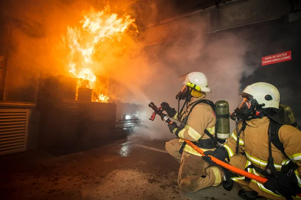 Feuerwehrmann Mit Wasser Und Feuerlöscher Bei Der Bekämpfung Der Flammen — Stockfoto