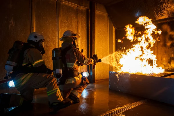 Feuerwehrmann Mit Wasser Und Feuerlöscher Bei Der Bekämpfung Der Flammen — Stockfoto