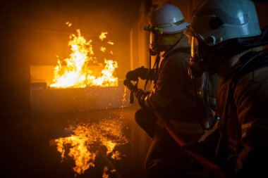 Yangın söndürücü ve su kullanan itfaiyeci, acil bir durumda yangın aleviyle mücadele eder. Tehlike anında bütün itfaiyeciler güvenlik için itfaiyeci kıyafeti giyer..